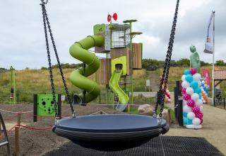 Parco giochi con scivolo, altalena e palloncini colorati a Beach Park Vlugtenburg 13 nei Paesi Bassi.