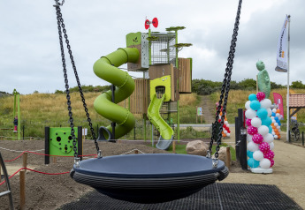 Parco giochi con scivolo, altalena e palloncini colorati a Beach Park Vlugtenburg 13 nei Paesi Bassi.