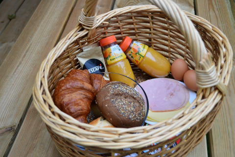 Breakfast basket at Beach Park Vlugtenburg 13 with juice, bread, eggs, and Nescafé, Netherlands.