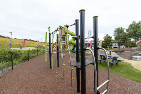 Playground with climbing equipment and slide at Beach Park Vlugtenburg 12 in the Netherlands, grassy area.