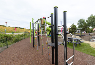 Playground with climbing equipment and slide at Beach Park Vlugtenburg 12 in the Netherlands, grassy area.