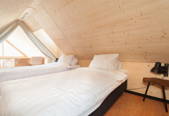 Soveværelse med to enkeltsenge i træinteriør i en tiny house på Eco Resort Grevelingenstrand, Holland.