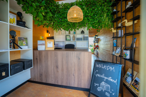 Accueil de l’Eco Resort Grevelingenstrand aux Pays-Bas, avec plantes vertes et panneau de bienvenue.