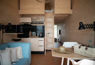 Intérieur d'une tiny house à l’Eco Resort Grevelingenstrand aux Pays-Bas, avec un décor moderne en bois.