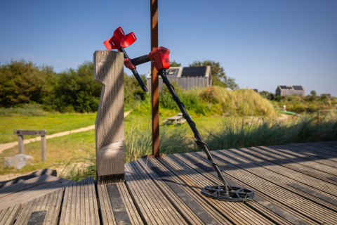 Un détecteur de métaux appuyé contre une barrière à l’Eco Resort Grevelingenstrand aux Pays-Bas au soleil.
