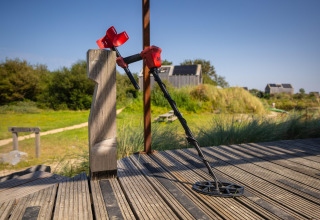 Un détecteur de métaux appuyé contre une barrière à l’Eco Resort Grevelingenstrand aux Pays-Bas au soleil.