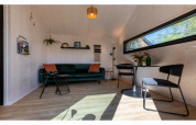 Salon lumineux et moderne dans le Tinyhouse «La Mouette» aux Pays-Bas, avec canapé et table à manger.