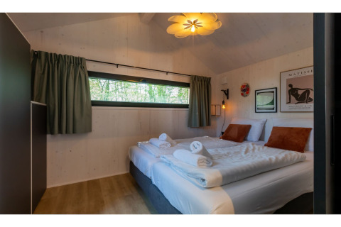 Gezellige slaapkamer in Tinyhouse La Mouette in Nederland, met twee bedden en stijlvolle inrichting.