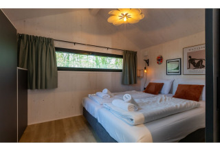 Gezellige slaapkamer in Tinyhouse La Mouette in Nederland, met twee bedden en stijlvolle inrichting.