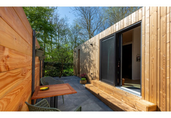 Terrasse extérieure au Tinyhouse «La Mouette» aux Pays-Bas avec murs en bois et mobilier moderne.