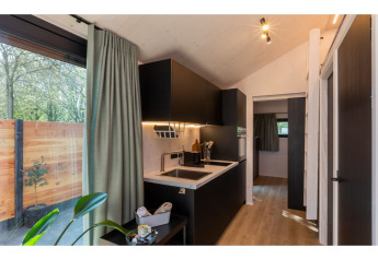 Coin cuisine moderne dans le Tinyhouse «La Mouette» avec vue sur terrasse et grande fenêtre, Pays-Bas.