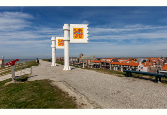 Chemin avec drapeaux et vue sur la ville près du Tinyhouse «La Mouette» face à la mer, Pays-Bas.