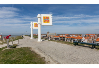 Chemin avec drapeaux et vue sur la ville près du Tinyhouse «La Mouette» face à la mer, Pays-Bas.