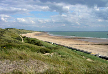 Vue depuis le Tinyhouse «La Mouette» aux Pays-Bas, dunes, plage de sable et ciel nuageux en arrière-plan.