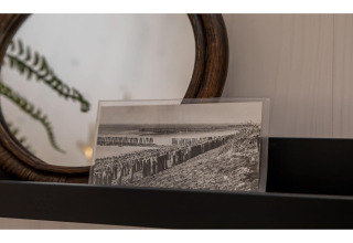 Zwart-witfoto op een plank naast een spiegel in Tinyhouse «La Mouette» in Nederland, met plant zichtbaar.
