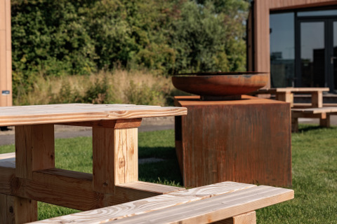 Banc en bois et brasero à la tiny house Noordzee, Résidence De Banjaard 22, aux Pays-Bas.
