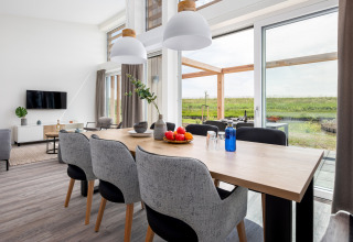 Lichte eet- en woonkamer in Water Village 4 in Nederland, met grote ramen en uitzicht op natuur.
