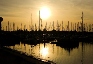 Zonsondergang boven zeilboten en masten bij Water Village 4 lodge, reflectie in het water, Nederland.