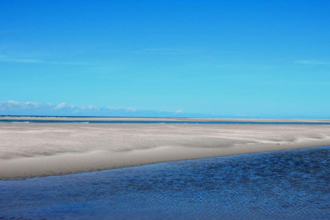 Uitzicht op zandbanken en zee onder heldere lucht bij Water Village 4 in Nederland.