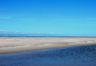 Uitzicht op zandbanken en zee onder heldere lucht bij Water Village 4 in Nederland.