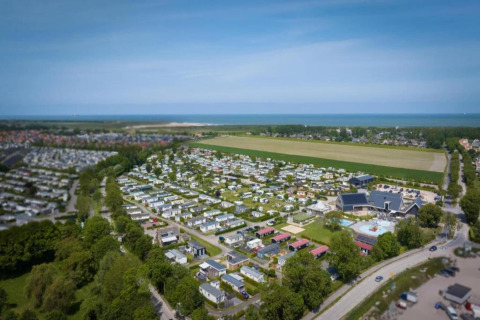Vista aérea del Beach Resort Nieuwvliet-Bad 15 en Países Bajos, con casas pequeñas y mar cercano.