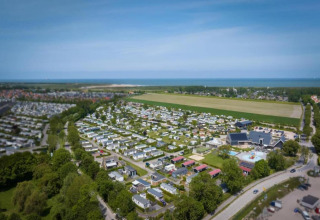 Vista aérea del Beach Resort Nieuwvliet-Bad 15 en Países Bajos, con casas pequeñas y mar cercano.