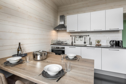 Moderne compacte keuken in Holiday Park Schaijk 3, Nederland, met eethoek en lichte houten afwerking.
