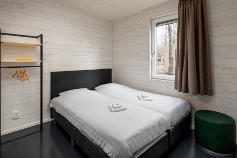 Moderne slaapkamer met twee eenpersoonsbedden in Holiday Park «Schaijk 3», Nederland, houten interieur.