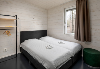 Chambre moderne avec deux lits simples et murs en bois au Holiday Park «Schaijk 3» aux Pays-Bas.