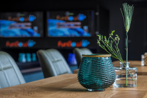 Moderne Tischdekoration mit blauer Vase und Pflanzen im Holiday Park ‚Schaijk 3‘ in den Niederlanden.