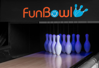 Bowling pins lit with blue lights below a FunBowl sign at a neon-themed bowling alley lane.