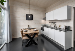 Modernes, kleines Küchen- und Esszimmer im Holiday Park «Schaijk 1» in den Niederlanden mit hellem Interieur.