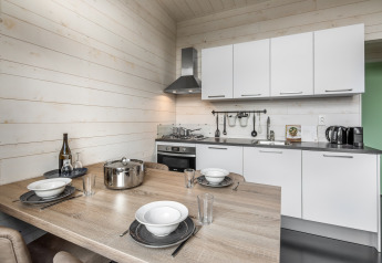 Petite cuisine moderne avec table à manger et armoires blanches à Holiday Park «Schaijk 1», Pays-Bas.
