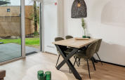 Coin repas moderne dans une tiny house au Holiday Park Schaijk 6 aux Pays-Bas avec vue sur le jardin.