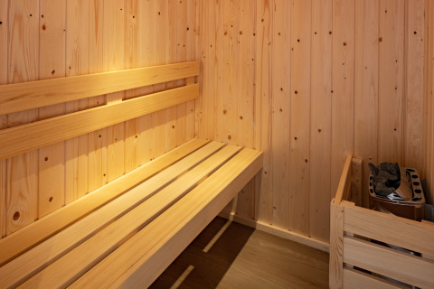 Innenraum einer kleinen Holzsauna mit Bank und Ofen im Holiday Park «Schaijk 6» in den Niederlanden.