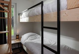 Modern bunk beds in a compact room at Holiday Park Schaijk 7 in the Netherlands, with natural wood accents.
