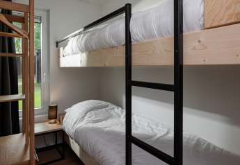 Lits superposés contemporains dans une chambre compacte au Holiday Park Schaijk 7, Pays-Bas, bois naturel.