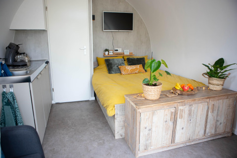Moderne pod med gul seng, lille køkken og træmøbler, fotograferet i 'De Ree en de Specht', Holland.