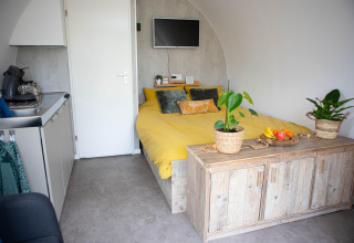 Moderne pod med gul seng, lille køkken og træmøbler, fotograferet i 'De Ree en de Specht', Holland.