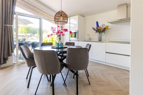 Modernes Esszimmer und Küche im Ferienhaus Molenvelden 8 in den Niederlanden mit viel Tageslicht.