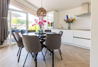 Modernes Esszimmer und Küche im Ferienhaus Molenvelden 8 in den Niederlanden mit viel Tageslicht.