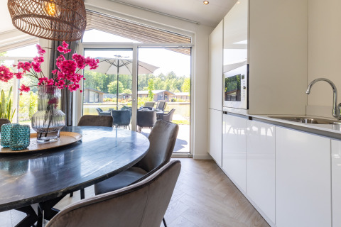Cuisine et salle à manger modernes du chalet Holiday Park Molenvelden 8, avec vue sur la terrasse extérieure.