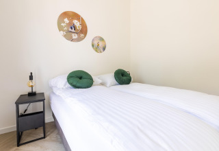 Camera luminosa presso Holiday Park «Molenvelden 8» nei Paesi Bassi con letto matrimoniale e decorazioni.