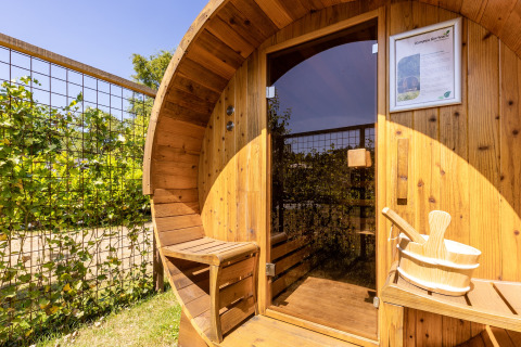 Udendørs træsauna med bænk og spand, solbeskinnet ved Holiday Park Molenvelden 8 i Holland.