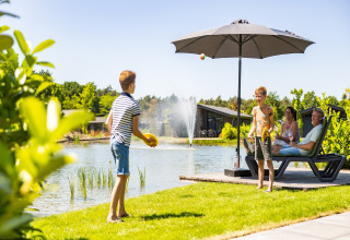 Famiglia si gode la giornata estiva al lago al Holiday Park Molenvelden 8, Olanda, bambini giocano.
