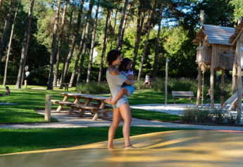 Donna con bambino in braccio nell’area giochi di Holiday Park Molenvelden 8 nei Paesi Bassi.