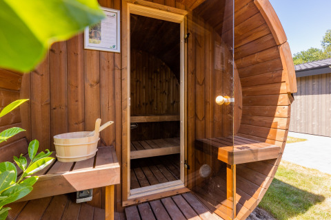 Sauna a botte in legno con porta in vetro e panca al Holiday Park Molenvelden 8 nei Paesi Bassi.