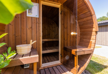 Sauna a botte in legno con porta in vetro e panca al Holiday Park Molenvelden 8 nei Paesi Bassi.