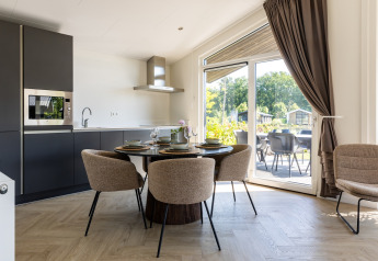 Cocina moderna de chalet y comedor con grandes ventanales y terraza en Holiday Park Molenvelden 7, Países Bajos.