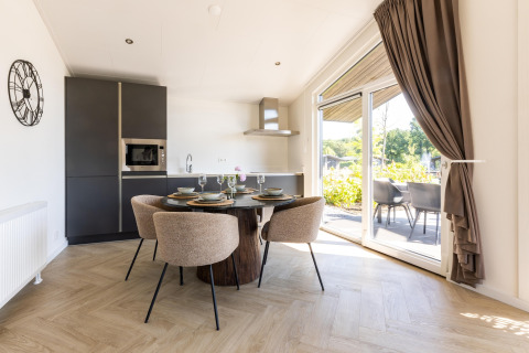 Lyst og moderne køkken og spiseområde i Holiday Park «Molenvelden 7» chalet i Holland, udsigt til terrassen.
